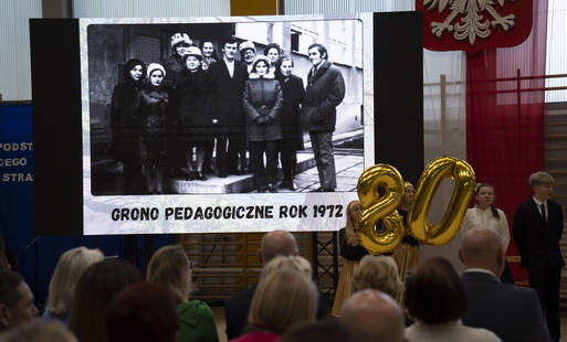 Zdjęcie z uroczystości, w tle prezentacja z archiwalnym zdjęciem grona pedagogicznego 